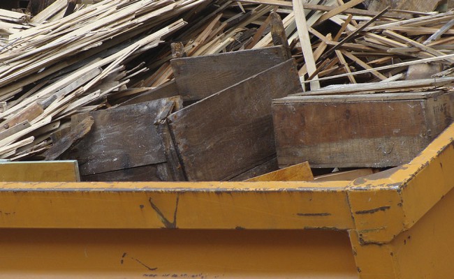 metal orange container filled with wood timber rubble